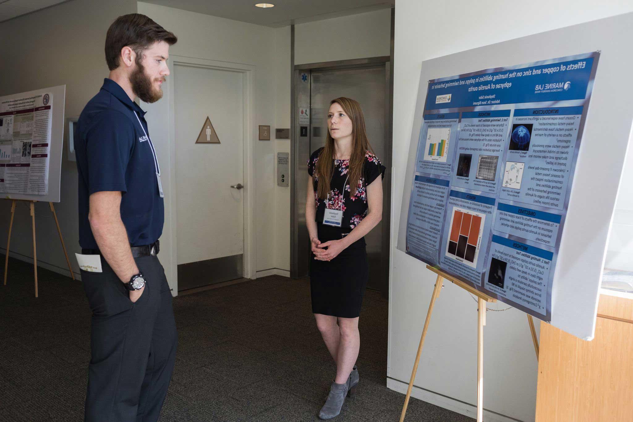 Noah Kolander viewing a female student's Marine Lab research poster